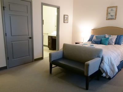 A private resident room featuring a bed and seating area