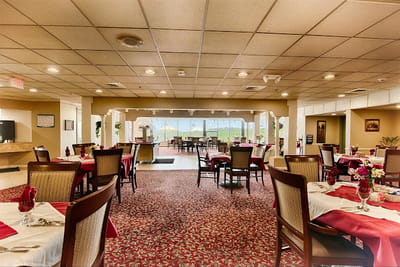 Dining room setup with tables and chairs for residents