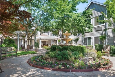 Sunny outdoor garden area with fountain and seating