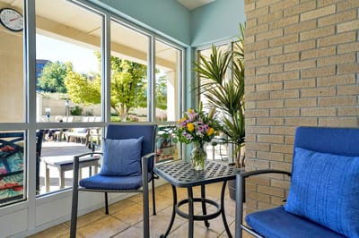 A cozy outdoor seating area with flowers and chairs