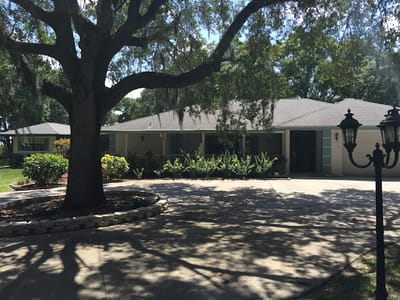 Exterior view of The Ranch Assisted Living with garden and trees