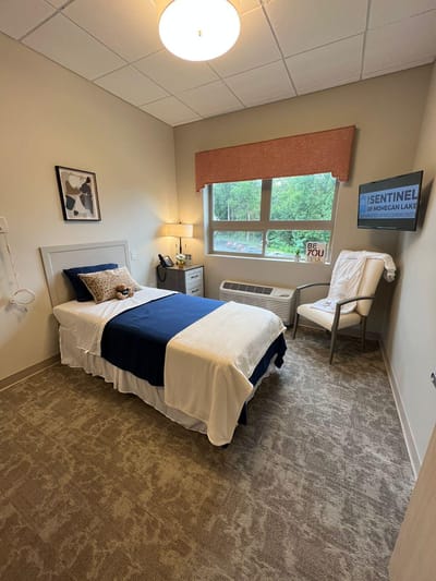 Cozy patient room with a bed and chair