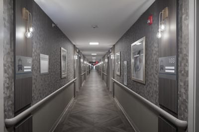 A well-lit hallway with resident room doors