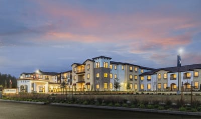 Exterior view of a senior living facility at sunset