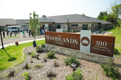 Exterior view of The Woodlands of DeWitt with signage
