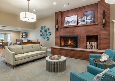 Common area with couches and fireplace in a senior living facility