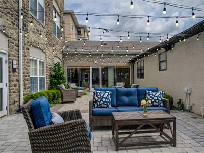 Outdoor seating area with string lights and greenery