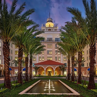 Exterior view of the facility with palm trees and fountain