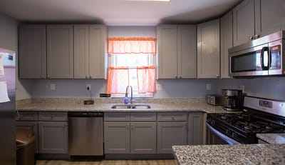 Modern kitchen with gray cabinetry and appliances.