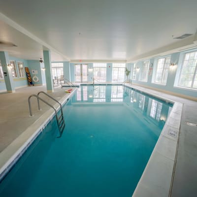Indoor swimming pool with large windows and lounge area