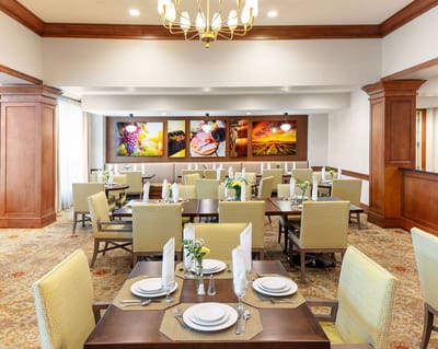 Dining room with table settings and artwork.