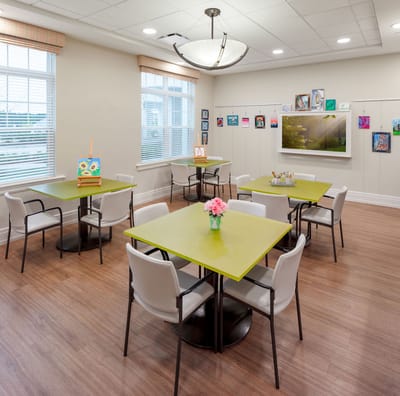 Bright activity room with colorful artwork and tables