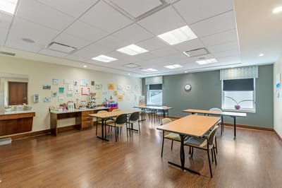 Bright common area with tables and art on the walls