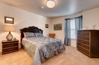 Cozy bedroom with a bed, dresser, and decor