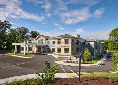 Exterior view of a senior living facility with landscaped entrance