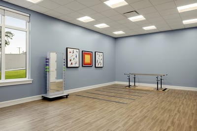 Bright activity room with ballet bar and mirrors
