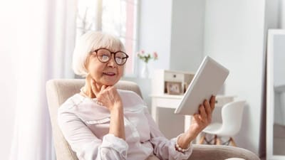 Senior resident enjoying a tablet in a bright lounge