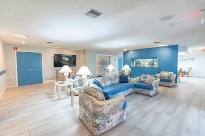 Bright common area with floral couches and lamps