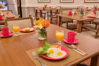 Dining room table set with breakfast meal and flowers