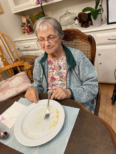 Resident finishing a meal at the dining table