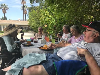 Residents enjoying a meal outdoors at Trinity Hills Estates