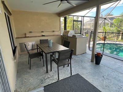 Covered outdoor seating area overlooking a pool