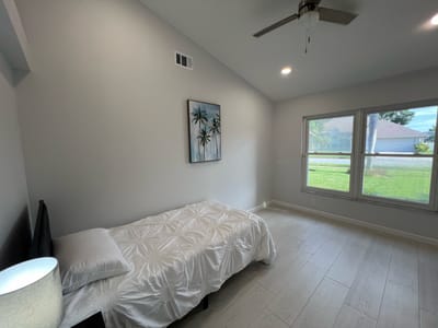 Light and airy private resident room with bed and artwork