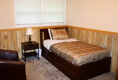Cozy private room featuring a bed and bedside table