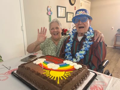 A resident celebrating a birthday with a staff member