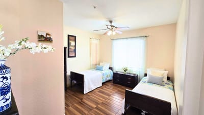 Brightly lit resident room with twin beds and decor