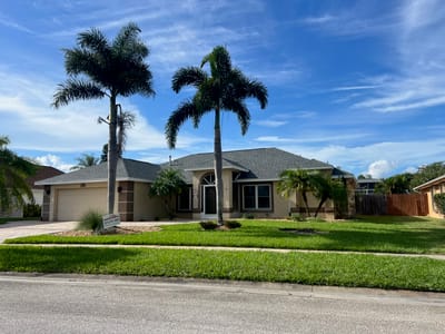 Exterior view of a senior living facility surrounded by palm trees