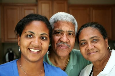 Three smiling individuals posing together indoors