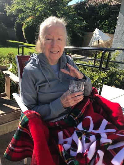 Senior resident enjoying the outdoors with a drink
