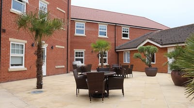 Outdoor seating area with palm trees and tables