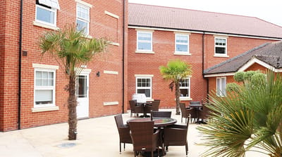 Outdoor patio area with tables and palm trees