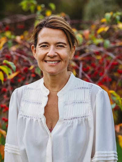 Smiling woman outdoors with natural background.