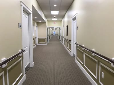 Empty hallway with residential doors and handrails