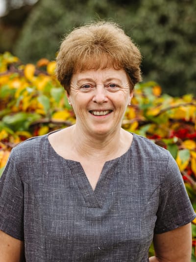Smiling staff member outdoors in a garden