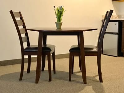 Small dining table set with chairs and flowers