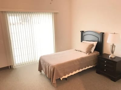 Private resident room with a bed and lamp.