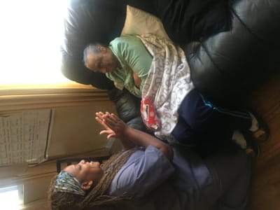 Caregiver interacting with a resident on a couch.