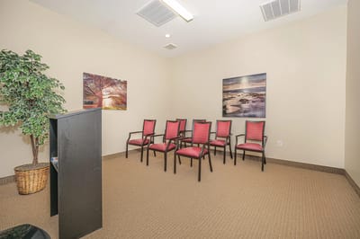 Interior room with chairs and artwork on the walls.