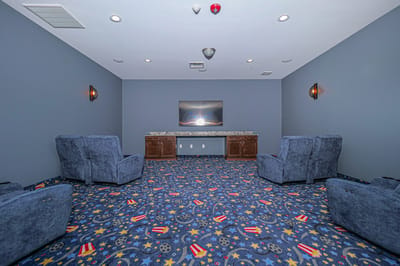 Common area with chairs and decorative carpet.