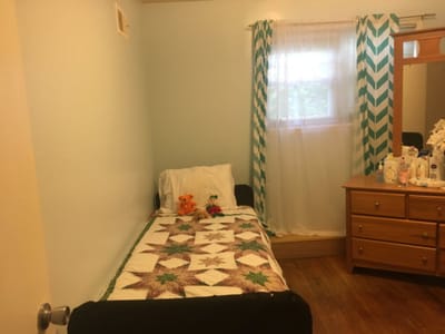 Cozy resident room with a quilted bed cover.