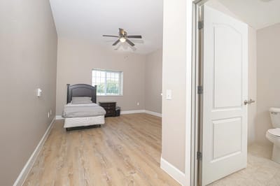 A private resident room with a bed and dresser.