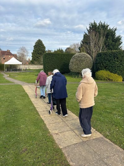 Residents walking on a pathway in a garden