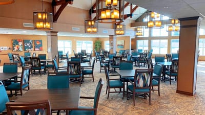 Bright dining room with tables and chairs arranged for residents