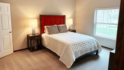 A well-furnished private bedroom in a senior living facility