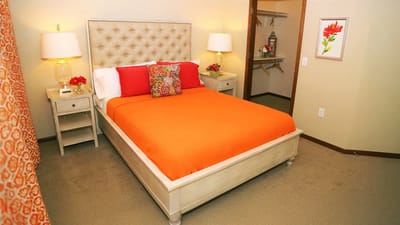 Cozy resident room with orange bedding and decor