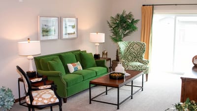 Cozy living area with green sofa and decorative chairs
